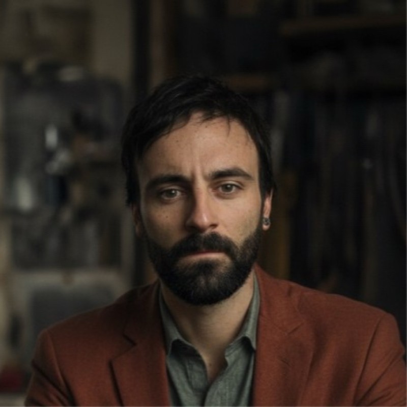 Riccardo Brunello ritratto in officina, giacca color mattone